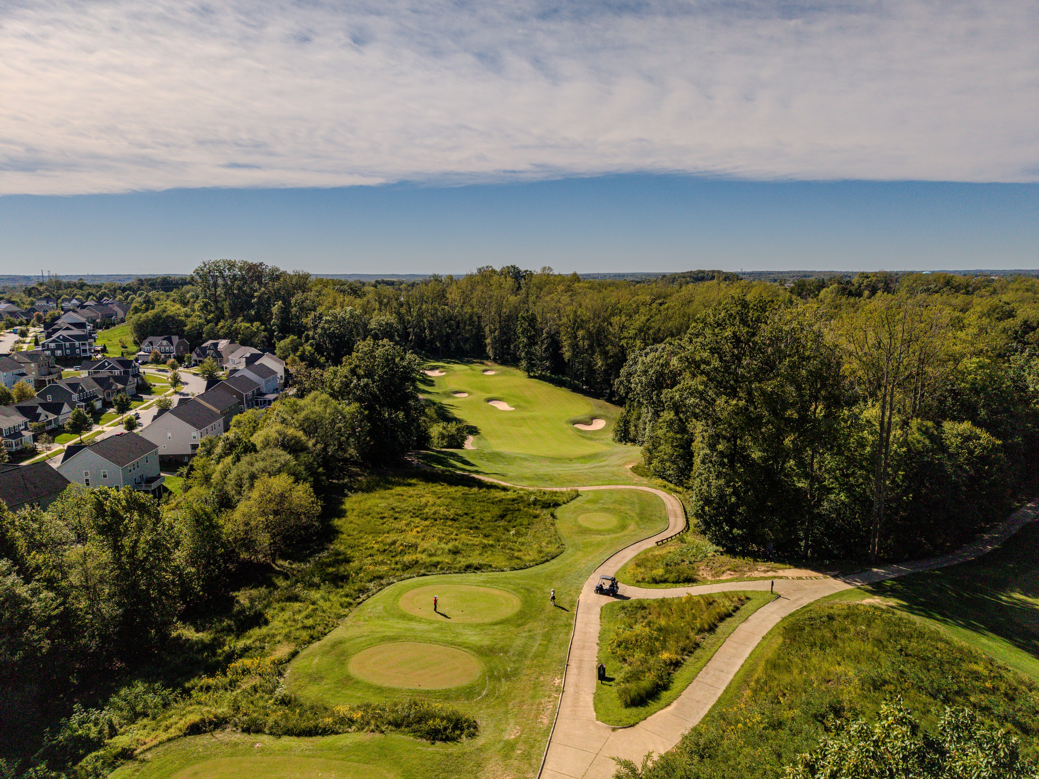 Aerial photograph of fairways winding through a wooded golf community